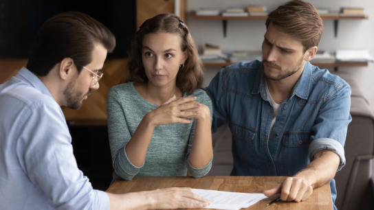 Couple of angry tenants having dispute with real estate agent, discussing complaint with lawyer, consulting legal expert